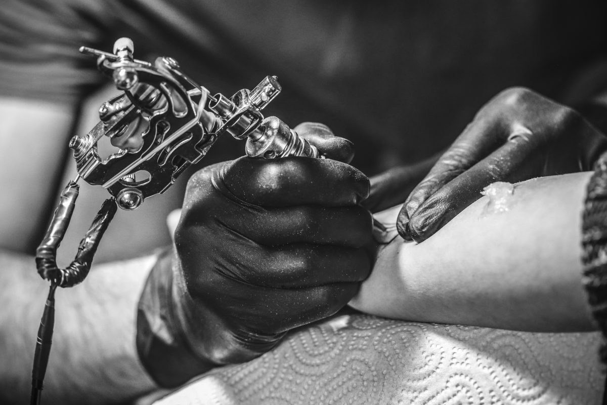 tattoo artist working on arm tattoo black and white why you should get a tattoo