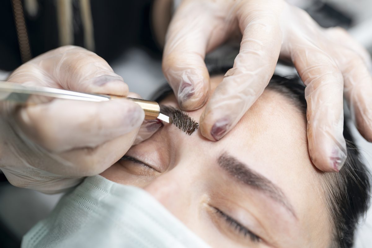 tattoo artist putting on permanent eyebrow makeup cosmetic tattoo